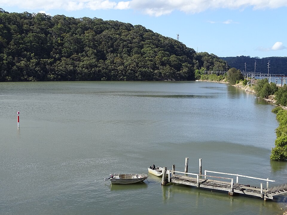 Jetty and small boats beside the bushland foreshore at Brooklyn NSW