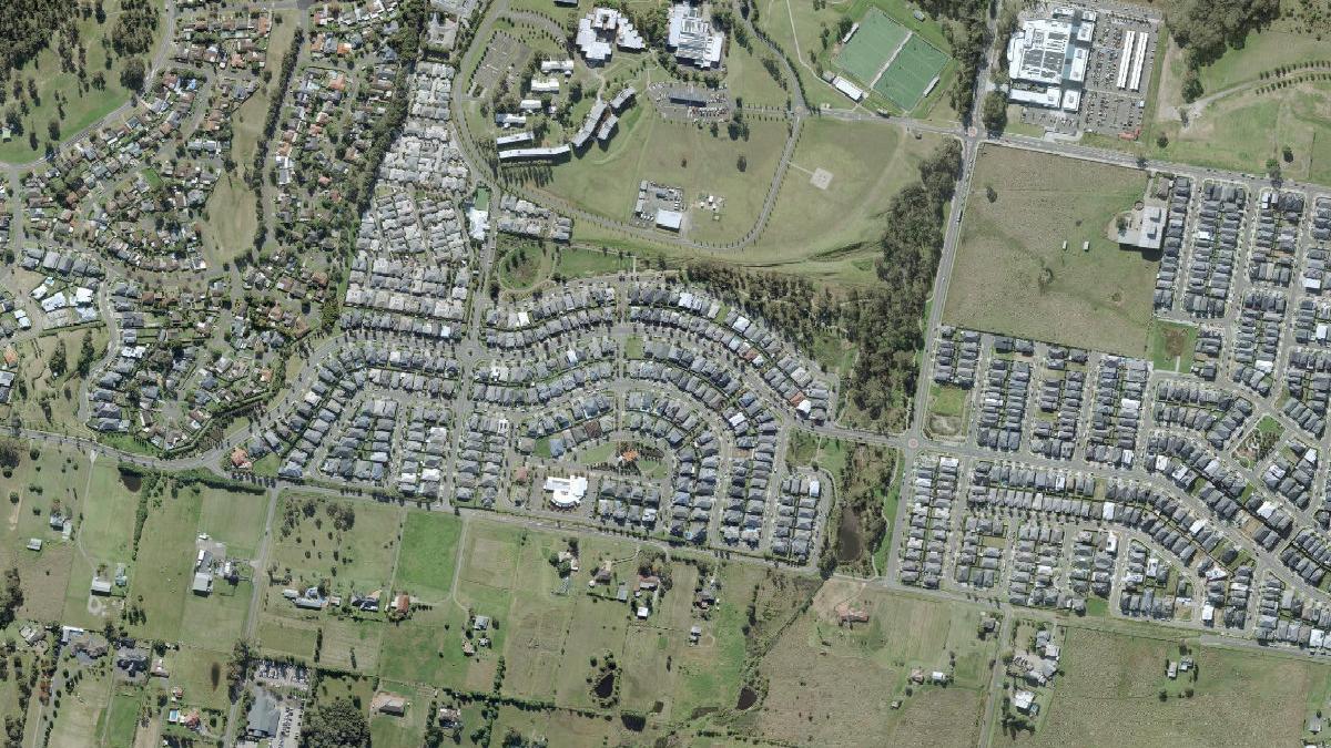 Aerial photograph centred on Caddens showing residential streets, open land and creek corridors
