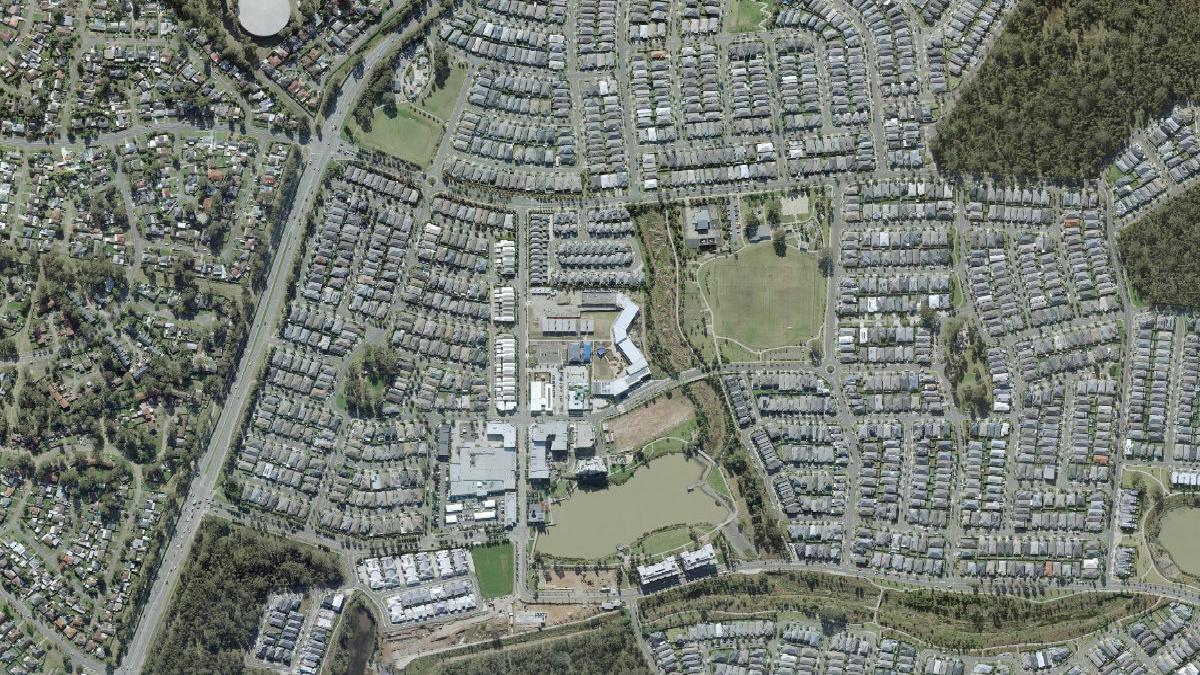 Aerial photograph centred on Jordan Springs showing the lake, residential streets, bushland and sporting areas